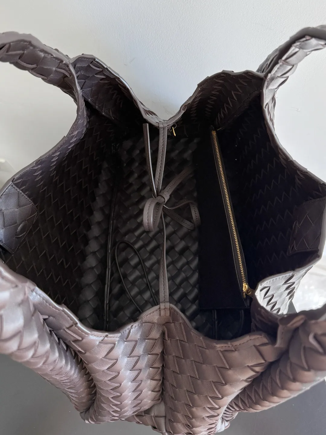 Batch 2760 new products are coming! BOTTEGA VENETA Bottega Veneta's 2025 new Campana shoulder bag is on the market~ First of all, I would like to praise the weight of this bag. As a not too small bag, it is very light for daily use. For people like me who need to carry a lot of belongings when going out, this advantage is great, and it greatly reduces the burden of traveling. 🛍️The shape is a bit like a combination of parachute and jodie. The blunt triangle shape is cute and honest. Carrying it on your back when going shopping is a good mood accelerator. The handles and body of the bag are both classic weaves. A tie is added to the original open design. If it is not tied up, the bag will look like a small vegetable basket when carried. Style number: 844250 Size: 39*24*18.5cm